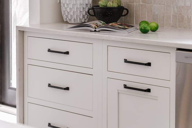 Cabinets painted white with a thin white marble countertop overtop and dropped over the side.