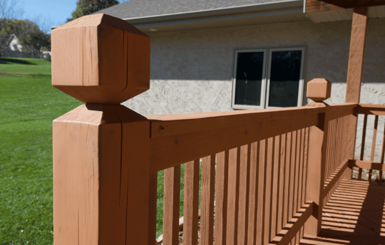 Close up of deck post after being stained with a warm brown stain in Omaha, NE.