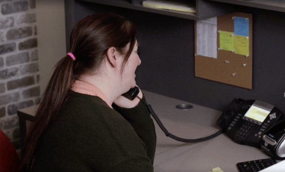 Office manager on the phone with a customer at Brush & Roll Painting.