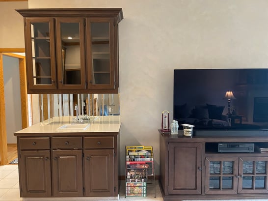 Dark brown stained cabinets in a living room kitchen area in Omaha, NE.