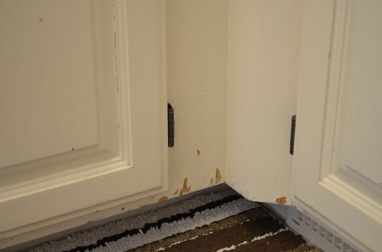 White cabinet doors and boxes with chipping paint along the bottom edges.