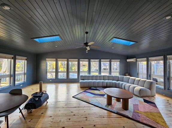 Large sunroom painted a dark grey blue color with a large grey couch in Omaha, NE.