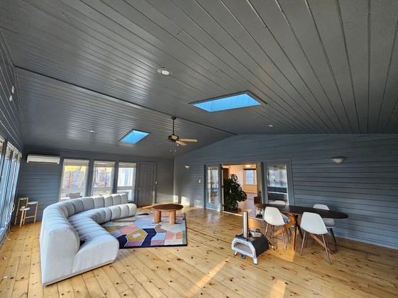 Dark painted sunroom with the same dark charcoal color on walls and ceilings.