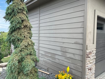 Exterior of house siding with dark discoloration and spots that need painted in Omaha, NE