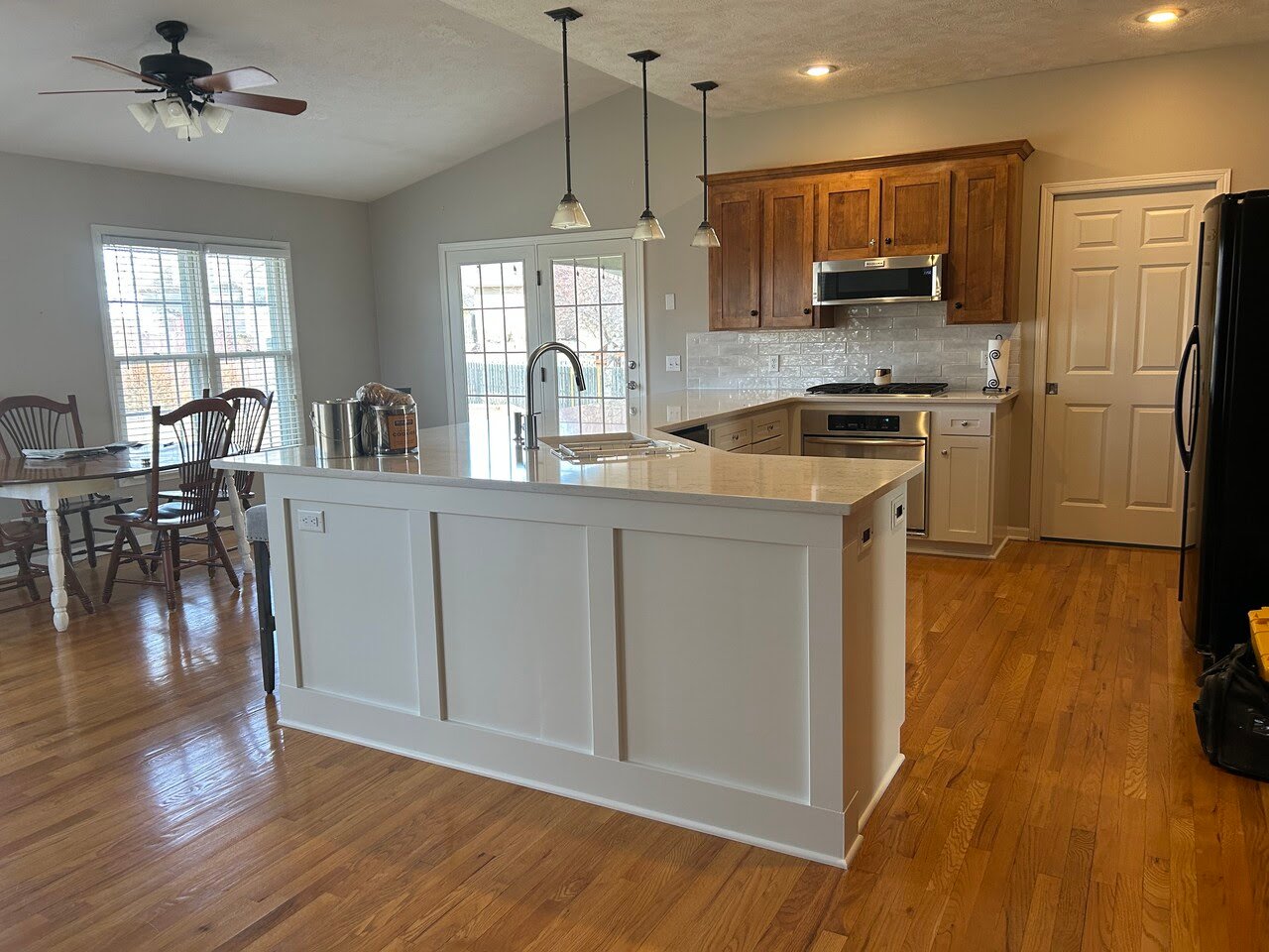 Kitchen with island painted white and perimeter cabinets stained.