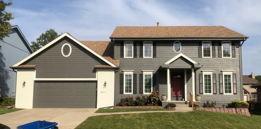 Grey exterior of home in Omaha with white trim and black shutters.