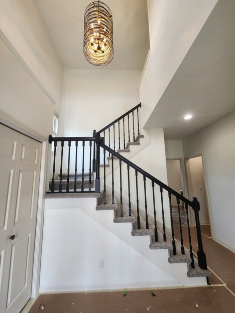 Entryway to a home with walls and ceiling painted white, with warm white doors and trim.