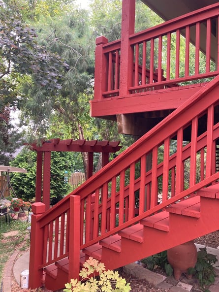 Deck painted a dark red color with descending stairs.