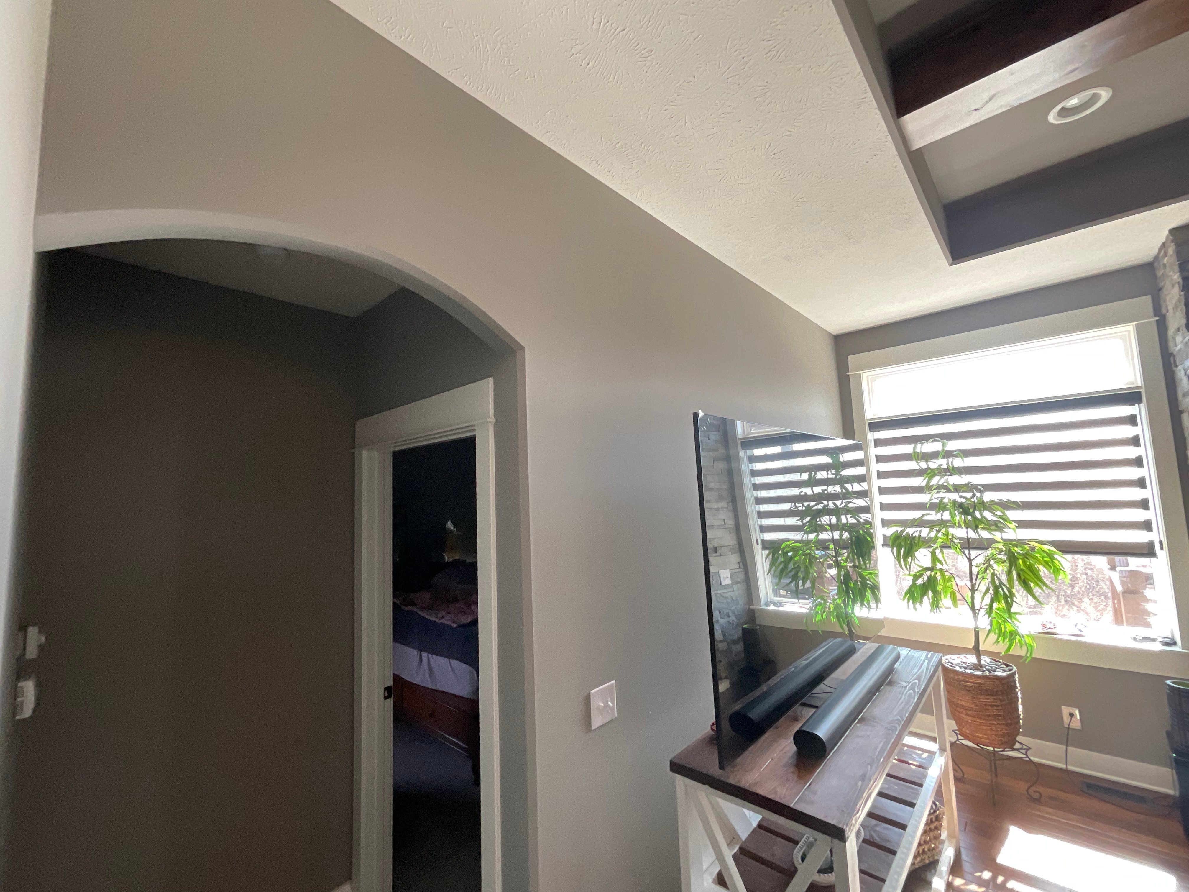 Interior living room walls painted grey with an archway before painting again.