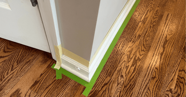 Baseboards taped off to prepare to be painted white inside a home in Omaha, NE.
