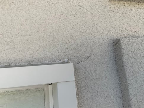 Close up of EIFS on a house with a crack in it by a window in Omaha, NE.