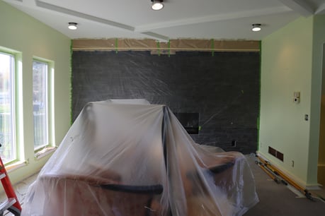 Furniture covered in a room with plastic tarp.