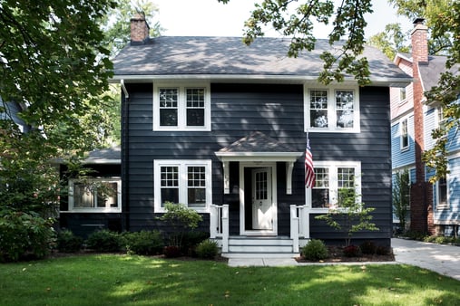 Home painted black with white window trim and front door and steps.