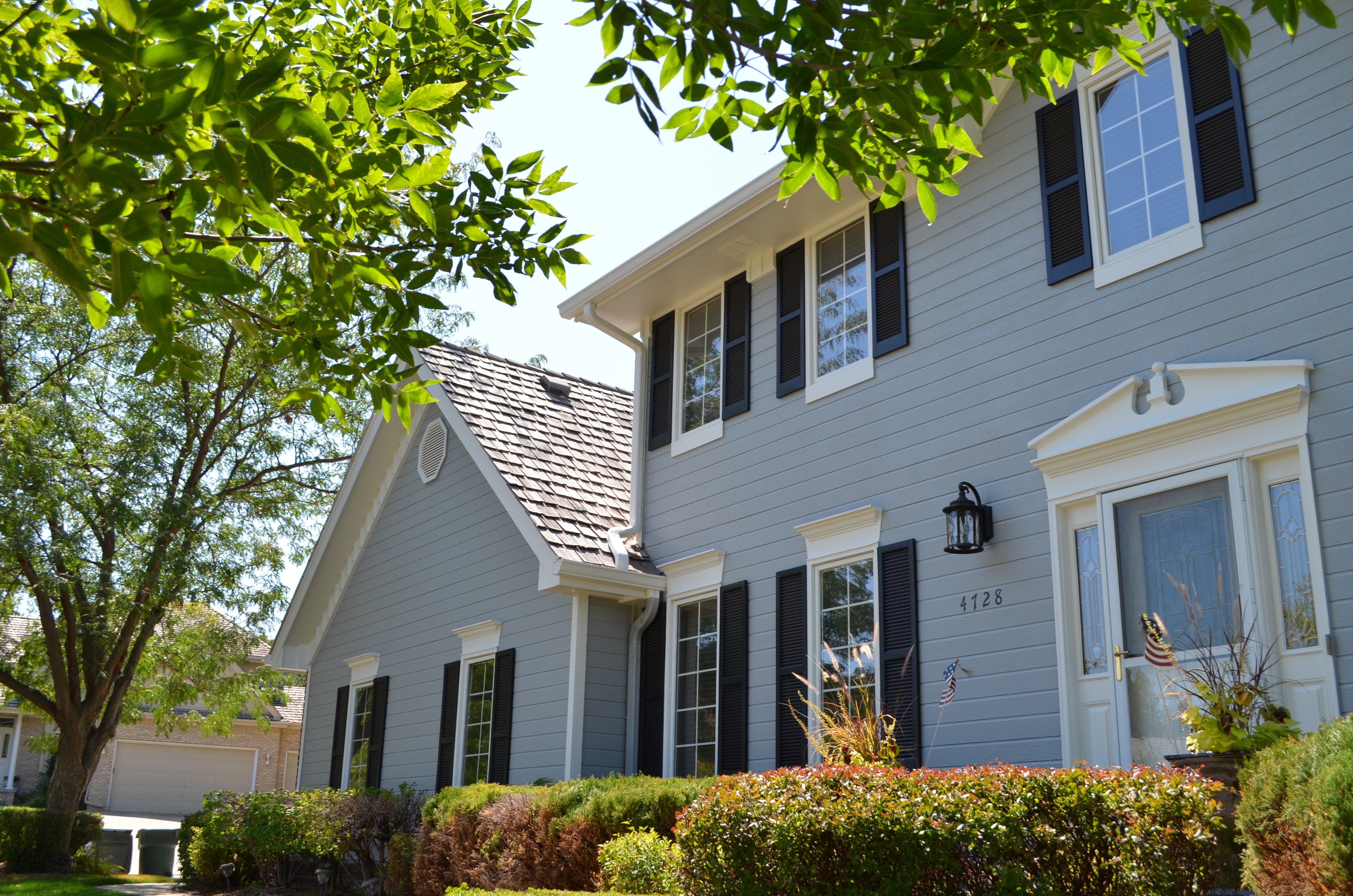 Exterior of home painted with light blue siding with dark blue shutters and white trim and doors in Blair, NE.
