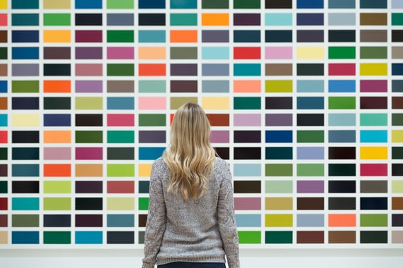 Woman choosing interior paint colors on large wall.