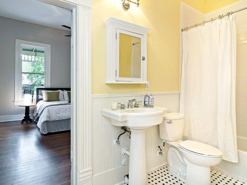 Small bathroom with yellow painted walls and white shiplap.