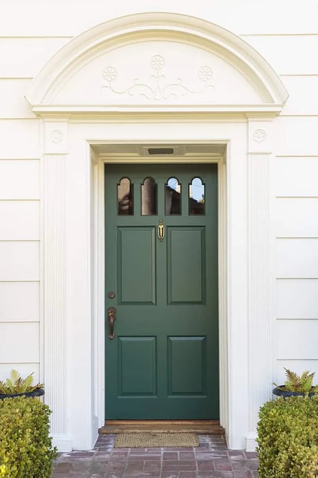 Dark green front door with a white exterior home.