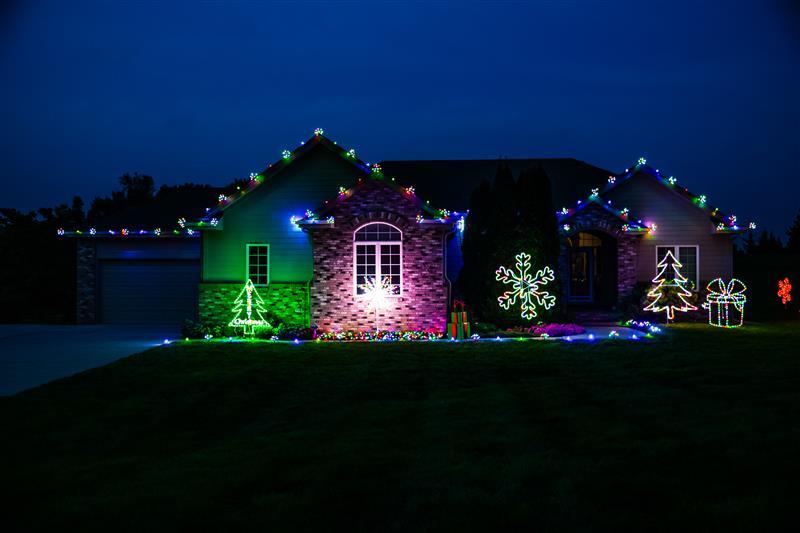 House in Omaha, NE with professionally installed Christmas lights with add on decorations along the front of the house.