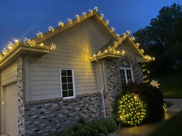 Glitzer bulbs on the roofline of a home in Omaha in a warm white color.