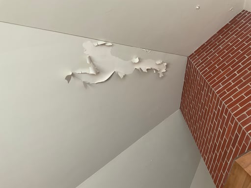 Large spot of peeling paint on a ceiling inside an Omaha Home painted white.