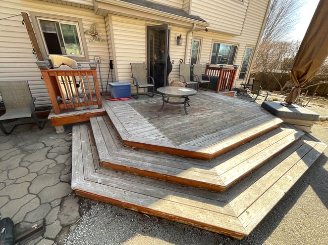 Back patio with wood planks with furniture on top.