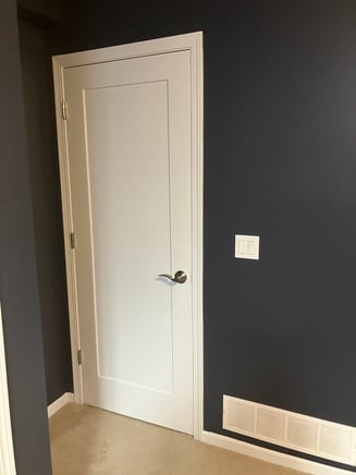 Interior door painted white with black walls.