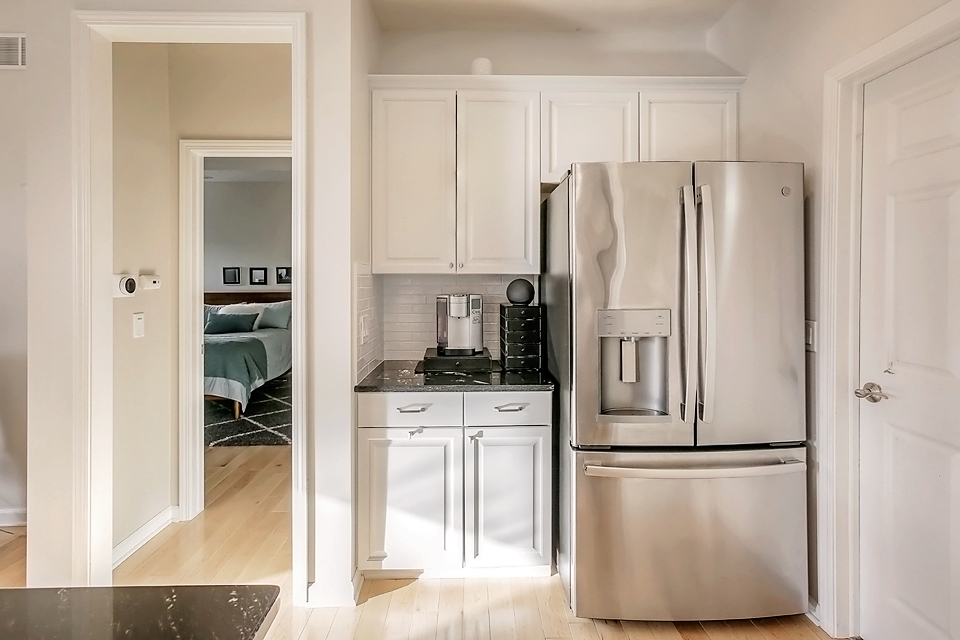 Kitchen with white cabinets and a stainless steel fridge.