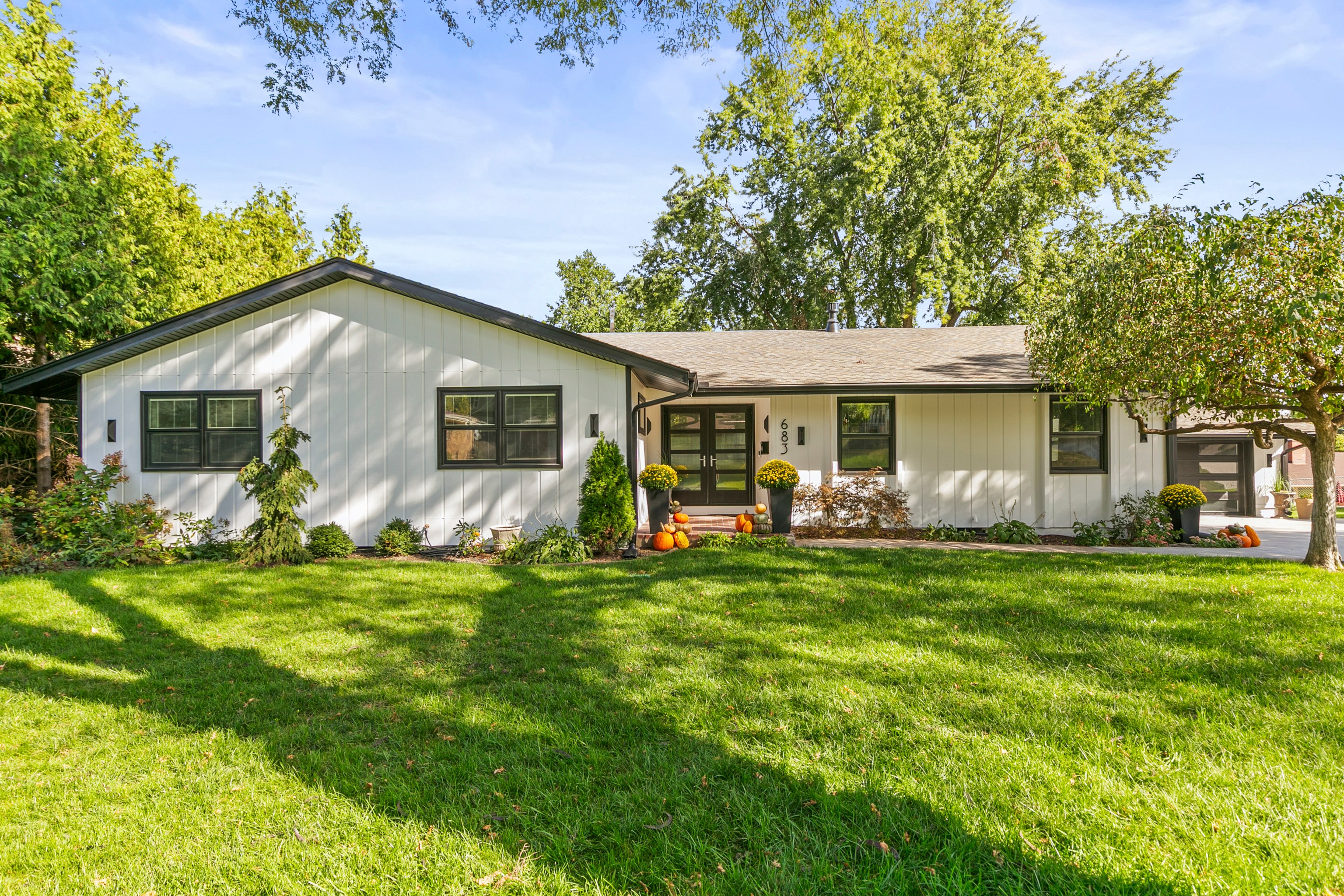 Exterior of house painted white with black trim around windows and doors in Omaha, NE.