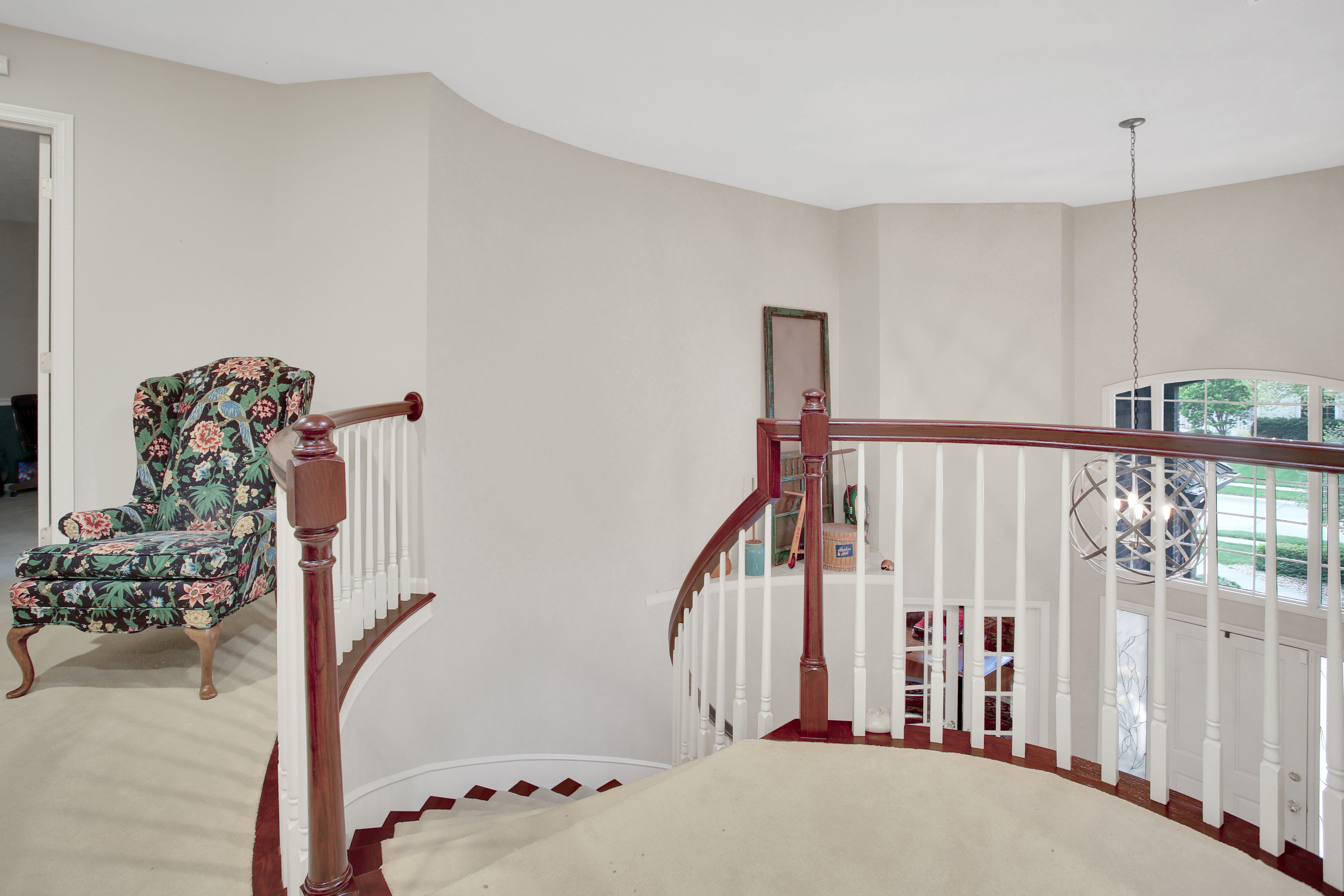 Top of stairs inside a Omaha home with warm brown and white railing and banisters.