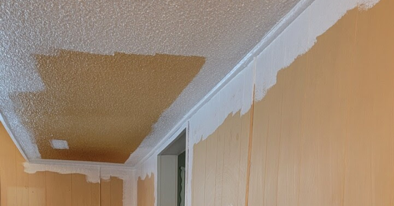 Outdoor textured ceiling and wood paneling at a home patio in the process of being painted white.