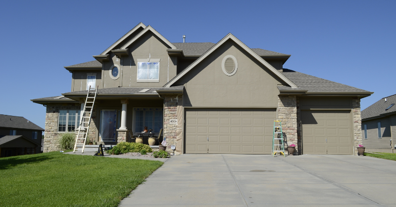 Exterior of neutral brown colored home in the process of being painted in Omaha, NE.