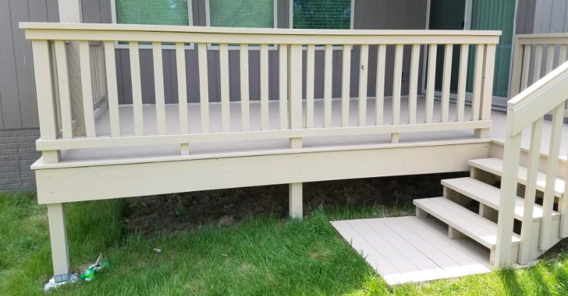 Solid white stained deck next to grey house with 4 steps.