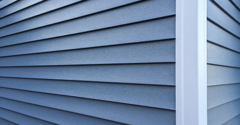Blue exterior siding with white trim on the side and corner of white.