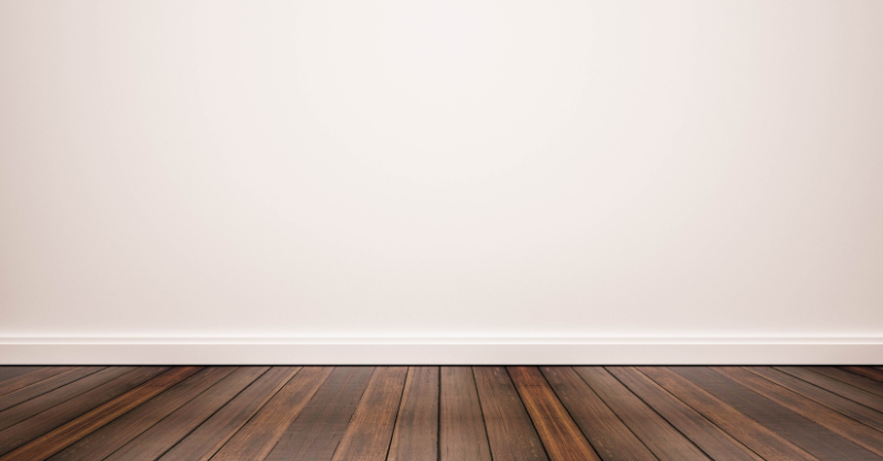 White wall and trim painted the same shade with dark hardwood floors