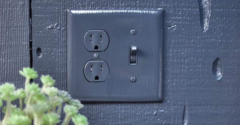 Navy blue painted wall outlet and light switch, photo credit: lovemaegan.com