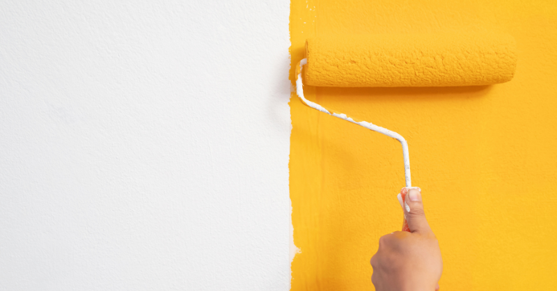 Yellow pain being rolled onto white wall in Omaha Nebraska.