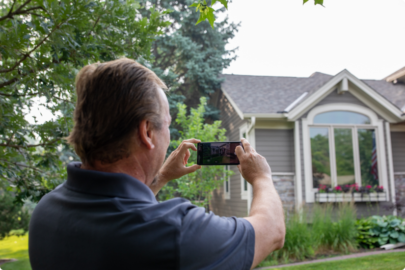 Man taking a picture of his home with the Hover app. Credit: Hover-Sean-Murphy-MN-0623149931