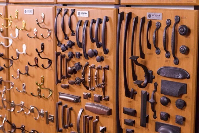 Black cabinet hardware samples displayed on wood.