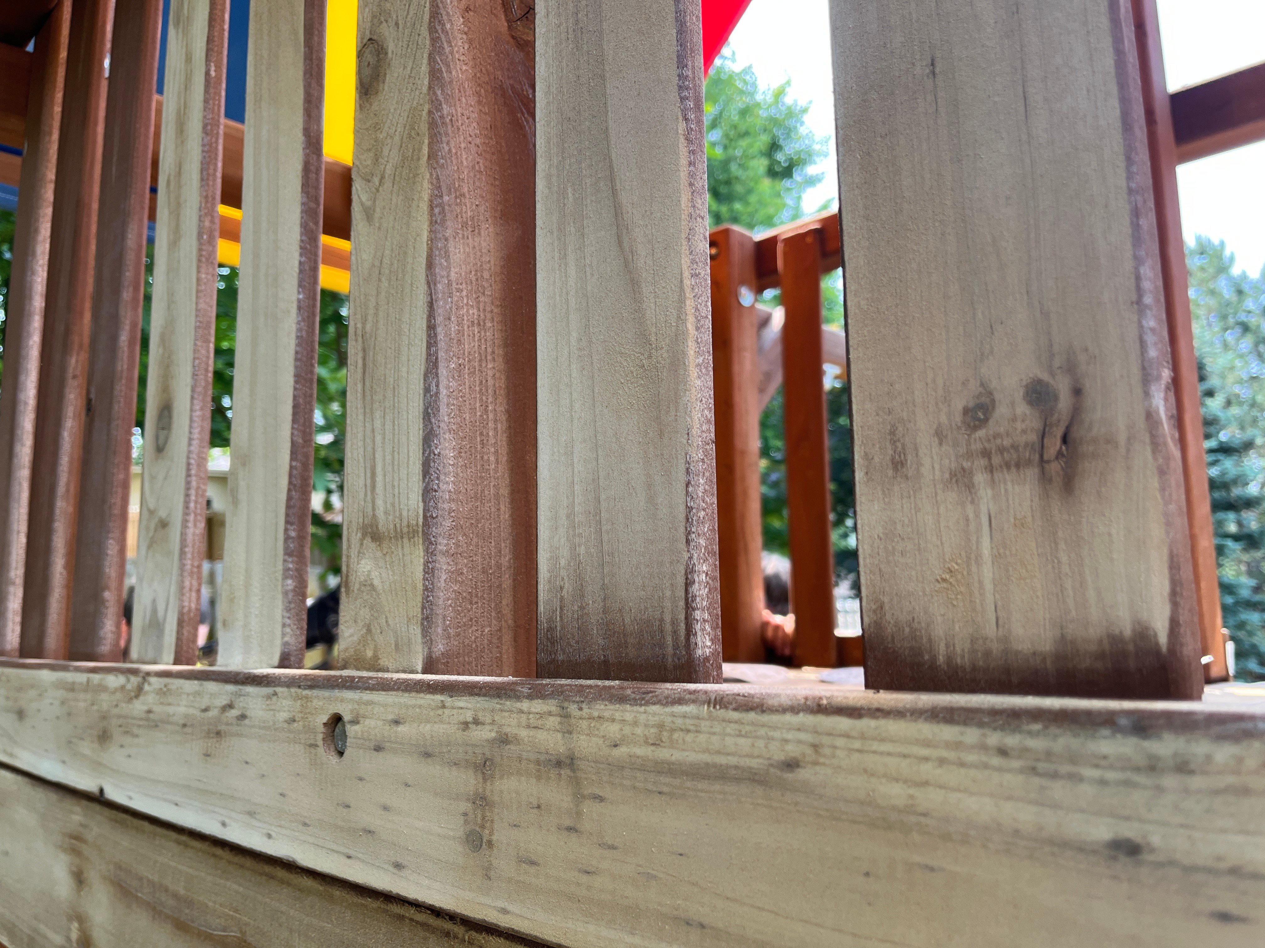 Wood playground with half of old stain sanded off before re-staining in Omaha.