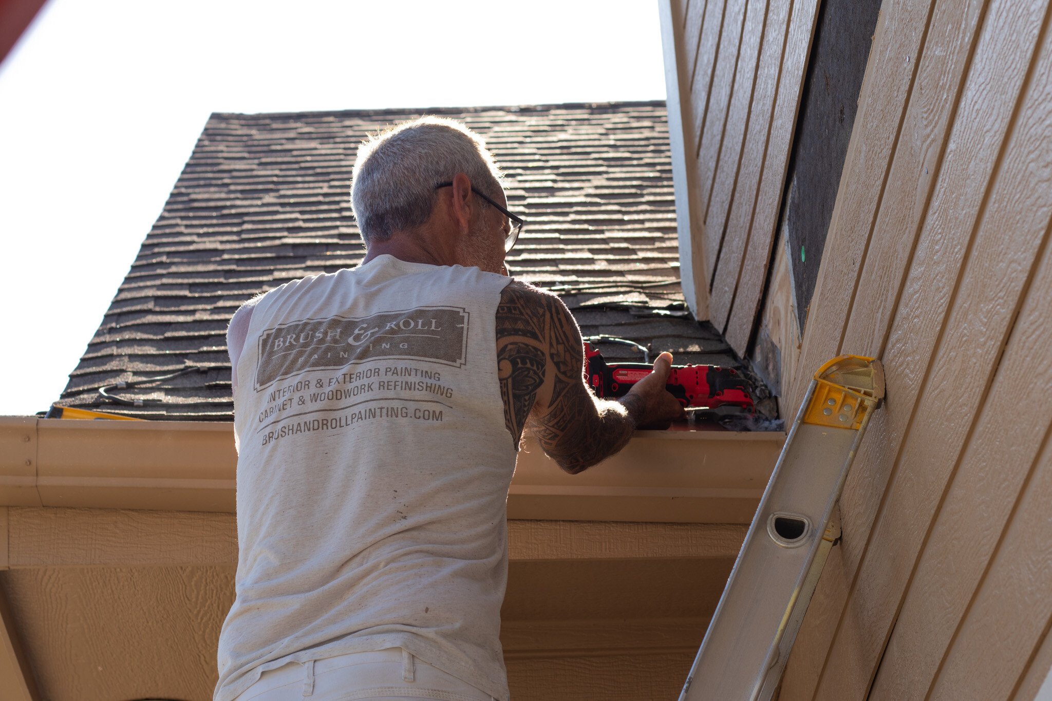 Brush & Roll Painting painter doing a siding repair on the exterior of a house in Omaha, NE.