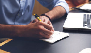 Man writing on paper with a pen