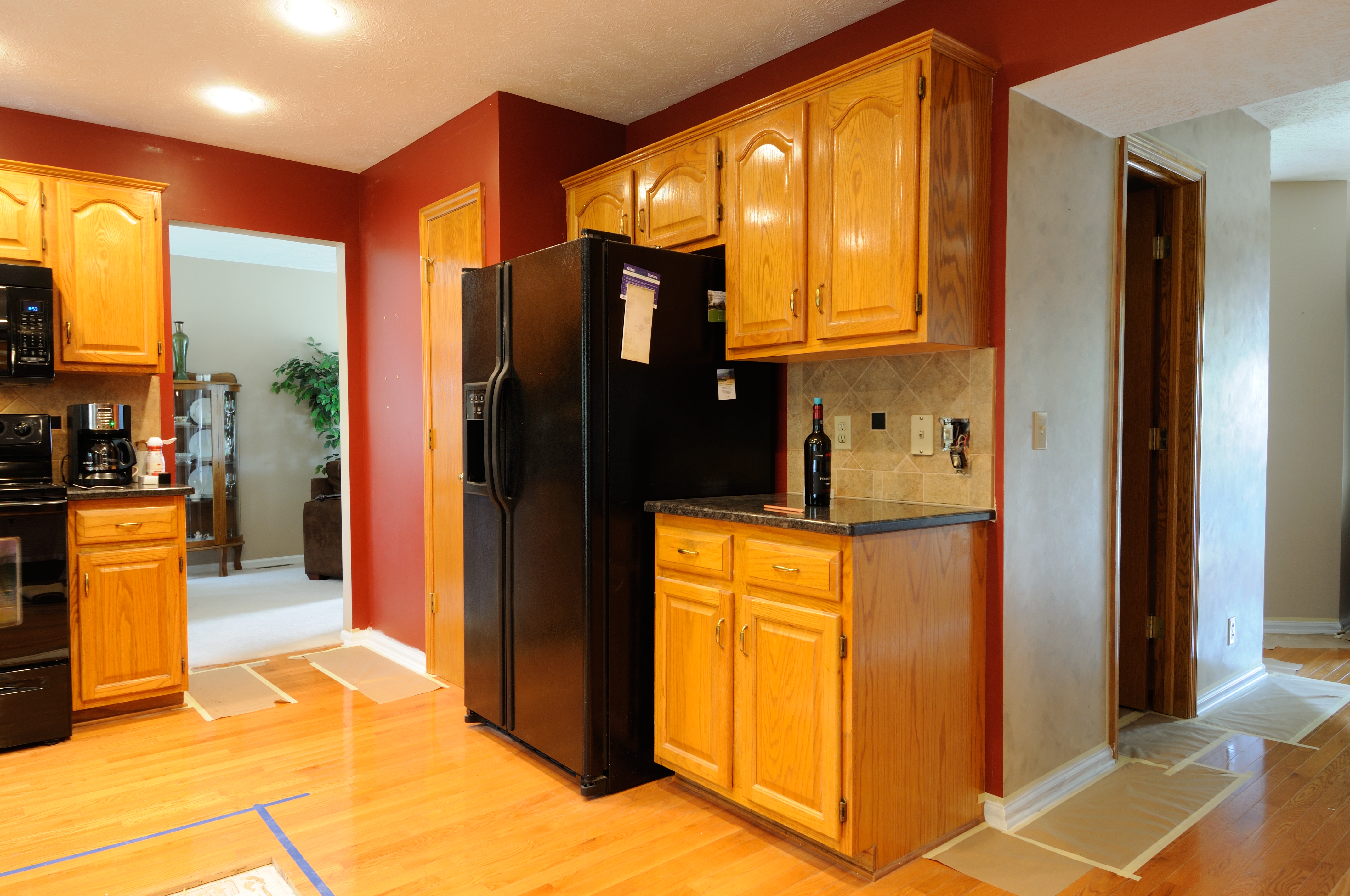 Kitchen with golden oak cabinets with oak floor and red painted walls.