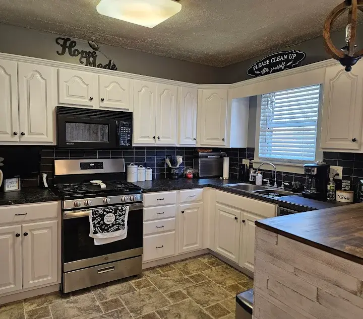 Kitchen with white cabinets and dark countertops.