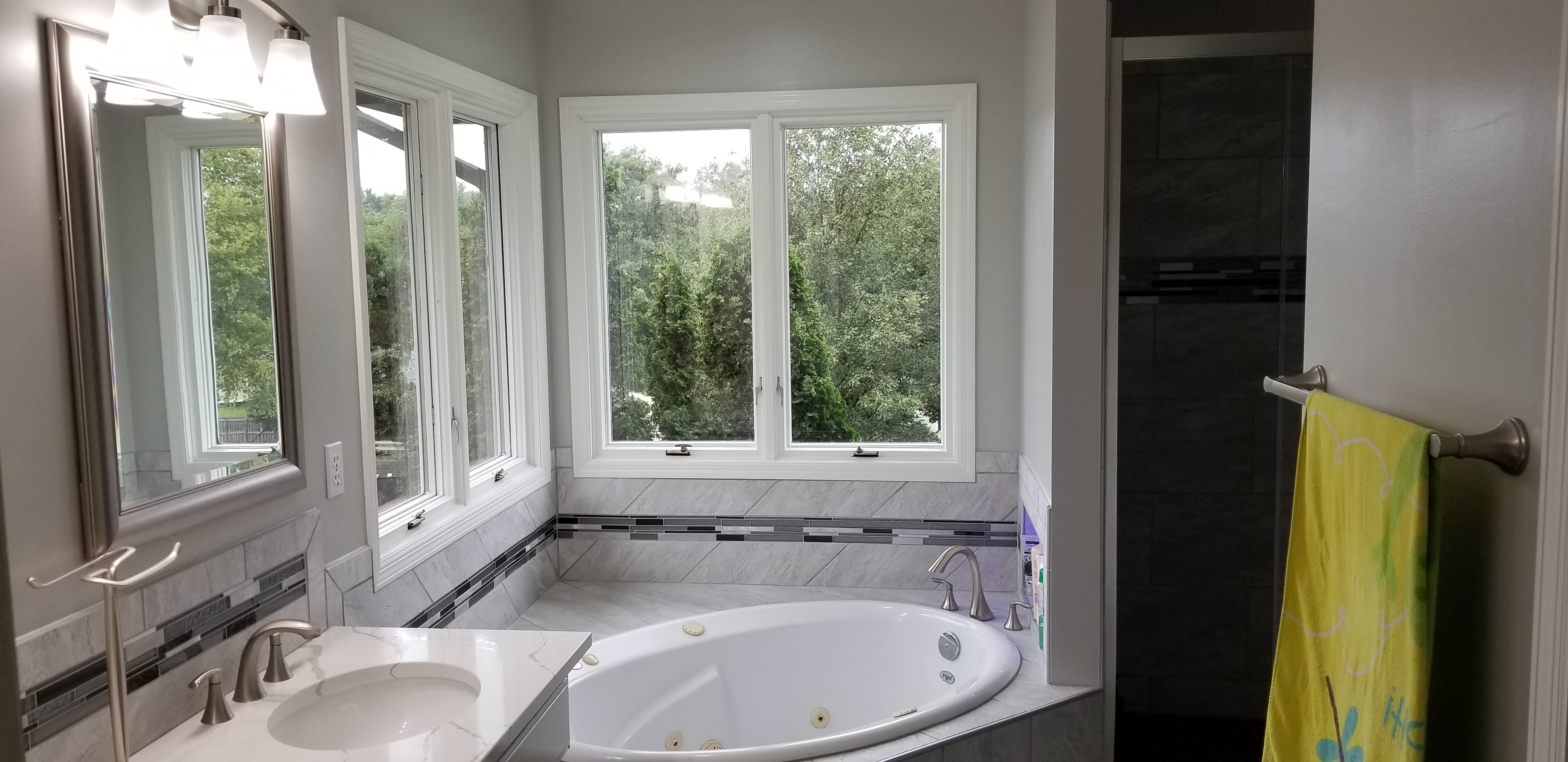 Bathtub with two windows with white trim