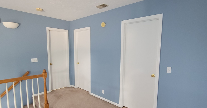 Freshly painted light blue interior walls with white trim, ceiling, and doors. 